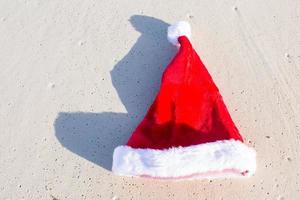 dichtbij omhoog de kerstman hoed Aan een wit zanderig strand foto