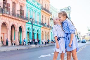 aanbiddelijk weinig meisjes in populair Oppervlakte in oud havanna, Cuba. portret van twee kinderen buitenshuis Aan een straat van Havana foto