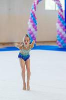 mooi weinig actief gymnast meisje met haar prestatie Aan de tapijt foto