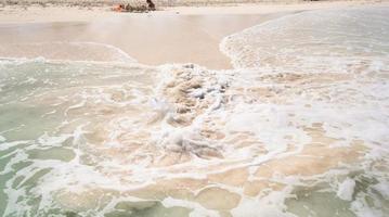 wit zanderig strand met turkoois water Bij perfect eiland foto