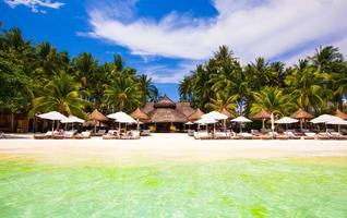 strand stoelen en paraplu's Aan exotisch tropisch wit zanderig strand foto