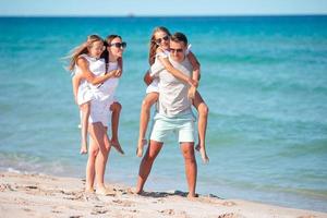 gelukkig familie Aan de strand gedurende zomer vakantie foto