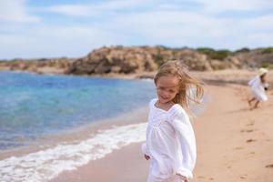 aanbiddelijk weinig meisje Bij tropisch strand gedurende vakantie foto