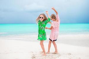 aanbiddelijk weinig meisjes hebben een veel van pret Aan de strand. twee mooi kinderen zijn happpy foto