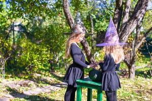 weinig meisjes gieten een spellen Aan halloween in heks kostuum foto