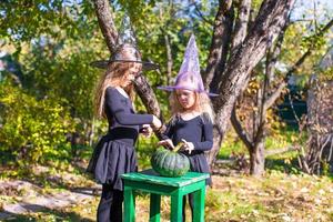 aanbiddelijk weinig meisjes in heks kostuum Aan halloween buitenshuis foto