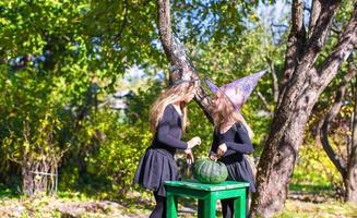 aanbiddelijk weinig meisjes in heks kostuum Aan halloween hebben pret foto