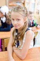 aanbiddelijk weinig school- meisje met aantekeningen en potloden buitenshuis. foto