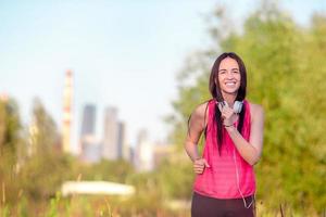 jonge glimlachende vrouw die sportieve oefeningen in openlucht doet foto