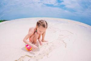 schattig weinig meisje Bij strand gedurende caraïben vakantie foto