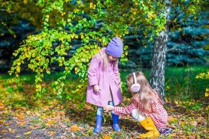 twee aanbiddelijk meisjes in Woud Bij warm zonnig herfst dag foto