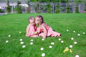 ouder zus zoenen jonger Aan een groen gras van Pasen eieren foto