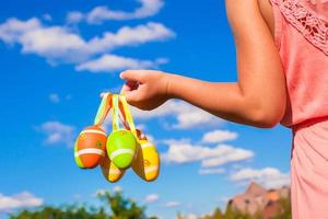 detailopname kleurrijk Pasen eieren in de handen van weinig mooi meisje achtergrond blauw lucht foto