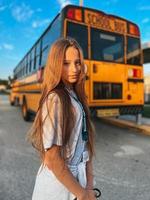 mooi tiener meisje krijgen Aan school- bus foto