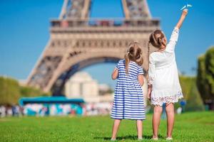 aanbiddelijk weinig meisjes in Parijs achtergrond de eiffel toren gedurende zomer vakantie foto