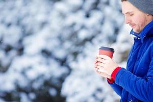 jong Kaukasisch Mens drinken koffie in bevroren winter dag buitenshuis foto