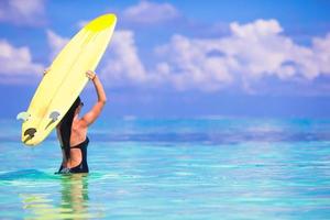 mooie surfervrouw die tijdens de zomervakantie surft foto