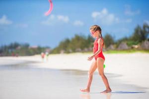 schattig weinig meisje Bij strand gedurende tropisch vakantie foto