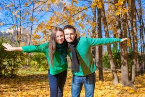 gelukkig familie van twee hebben pret in herfst park Aan een zonnig vallen dag foto