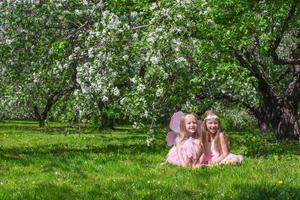 weinig schattig meisjes in de bloeiende appel tuin foto