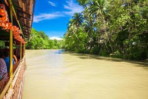 exotisch reis boot met toeristen Aan een oerwoud rivier- lobok, bohol foto