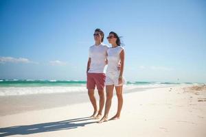 jong romantisch paar wandelen Aan exotisch strand in zonnig dag foto