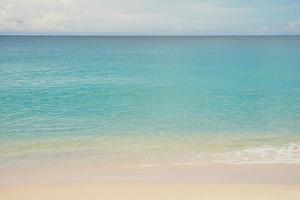 blauwe oceaan en zandstrand achtergrond foto