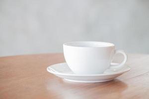 witte koffiekopje op een houten tafel foto