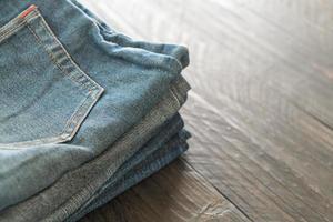 stapel jeans op houten vloer foto