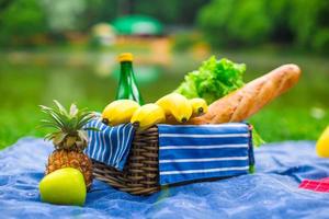 picknickmand met fruit, brood en fles witte wijn foto