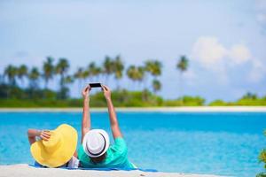 familie van twee maken een selfie met mobiele telefoon Aan strand foto