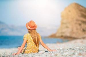 schattig klein meisje op het strand tijdens de zomervakantie foto