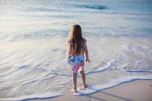 aanbiddelijk weinig meisje wandelen Bij wit tropisch strand foto