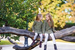 kleine schattige meisjes op warme dag in herfst park buitenshuis foto
