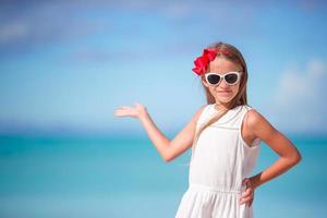 schattig weinig meisje Bij strand gedurende caraïben vakantie foto