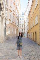 vrouw wandelen in stad. jong aantrekkelijk toerist buitenshuis in Europese stad foto