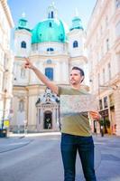 Mens toerist met een stad kaart in Europa straat. Kaukasisch jongen op zoek met kaart van Europese stad. foto