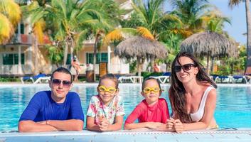 jong familie met twee kinderen genieten zomer vakantie in buitenshuis zwembad foto