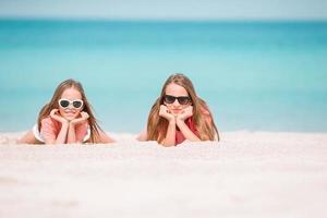 weinig gelukkig grappig meisjes hebben een veel van pret Bij tropisch strand spelen samen. foto