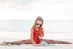 schattig weinig meisje Bij strand gedurende caraïben vakantie foto