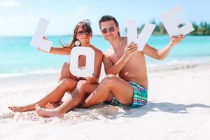 jong paar Aan wit strand gedurende zomer vakantie. foto