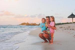 gelukkig mooi familie Aan een tropisch strand vakantie foto