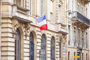 Frans vlag Bij facade van historisch gebouw in Parijs foto