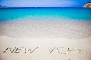 gelukkig nieuw jaar geschreven in de wit zand foto