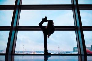 weinig meisje in luchthaven in de buurt groot venster terwijl wacht voor instappen foto