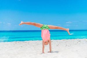 aanbiddelijk gelukkig weinig meisje hebben pret Aan strand vakantie foto