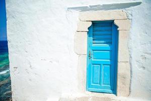 traditioneel huizen met blauw deuren in de versmallen straten van mykonos, Griekenland. foto