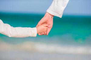 weinig meisje en gelukkig vader hebben pret gedurende strand vakantie foto