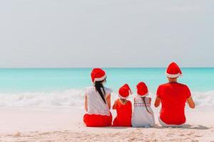 gelukkig familie met twee kinderen in de kerstman hoed Aan zomer vakantie foto