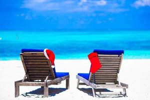 rood Kerstmis kous en de kerstman hoed Aan strand ligstoelen foto